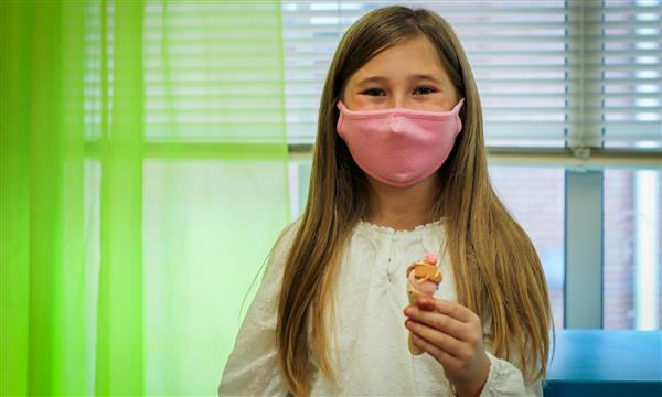 Girl holds up food model made of clay